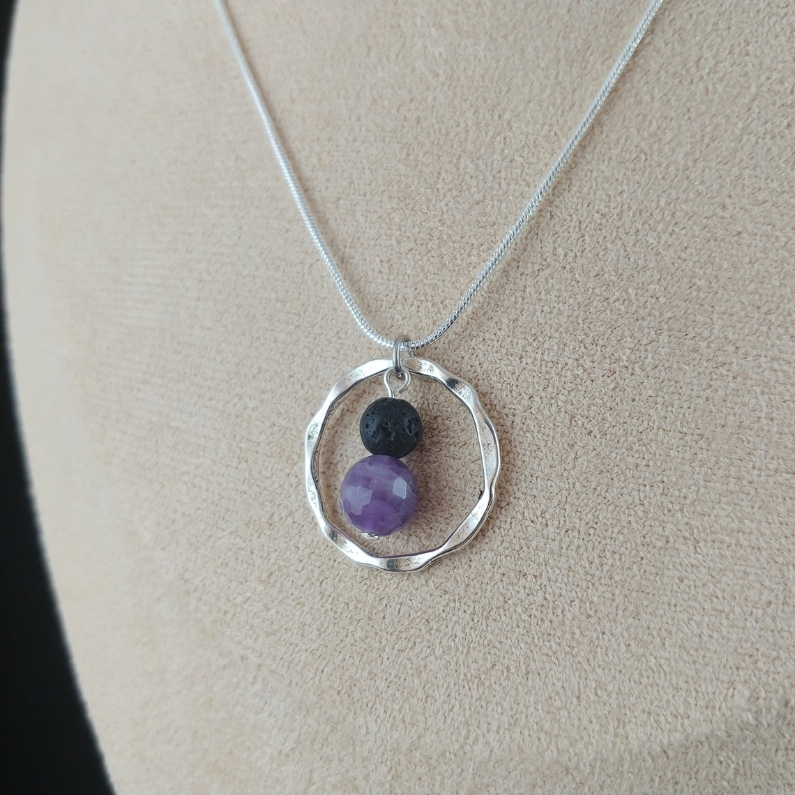 Silfur hálsmen með amethyst og lava steinum. Steinarnir hanga fyrir miðju í grófum silfur hring.
